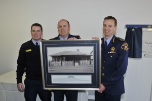 Constable Adam Bowden and Senior Constable Jason Prins present Commissioner Darren Hine with a historic photo of 'Glenmoor'. The house was owned by their great grandparents.