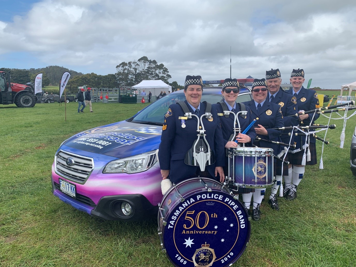 Tasmania Police Pipe Band holding their instruments smiling for a photo